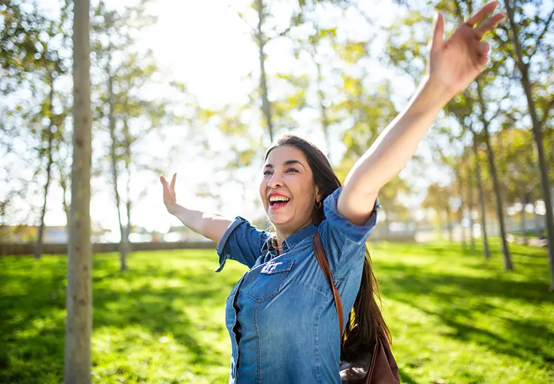 Woman walking in a park among trees