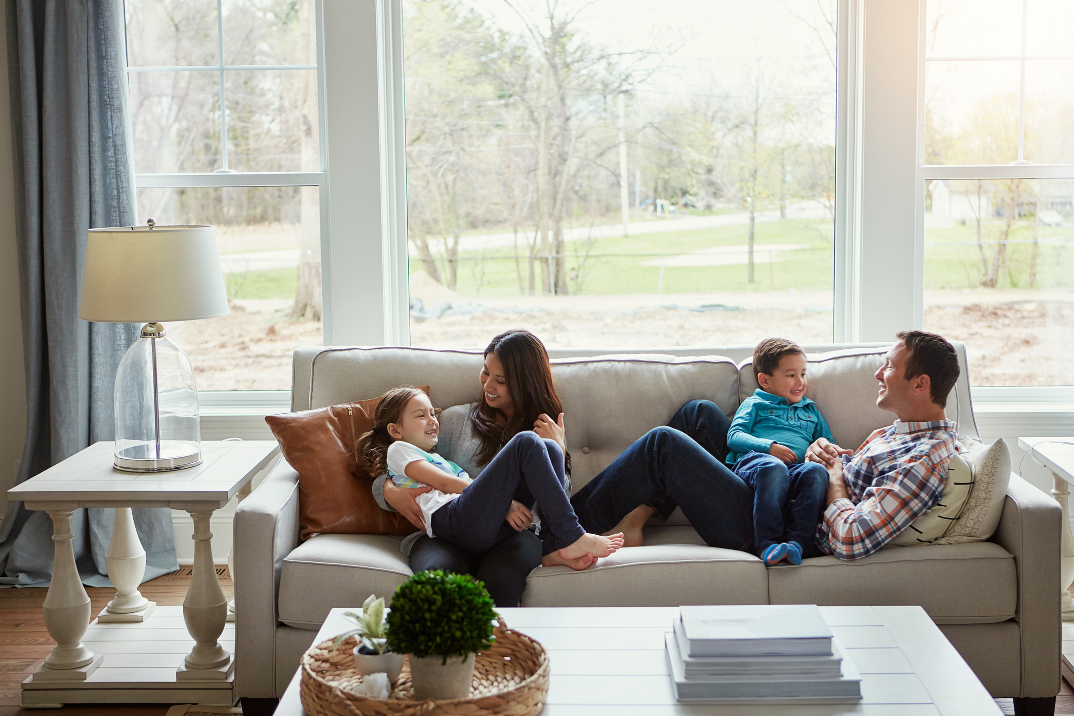 House + love = home Shot of a happy young family of four relaxing together on the sofa at home
